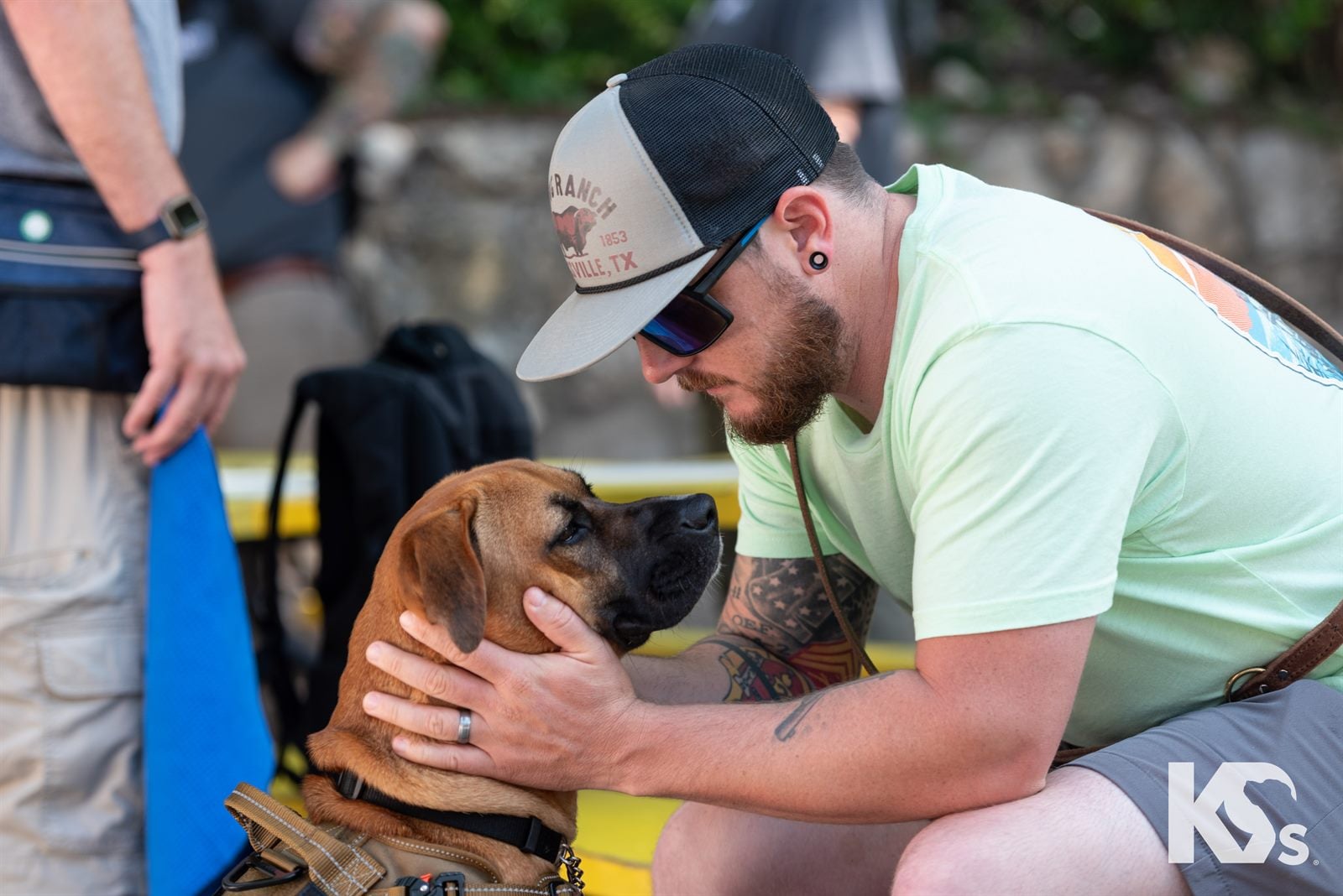 A Veteran leaning in toward his Service Dog while sitting outdoors.